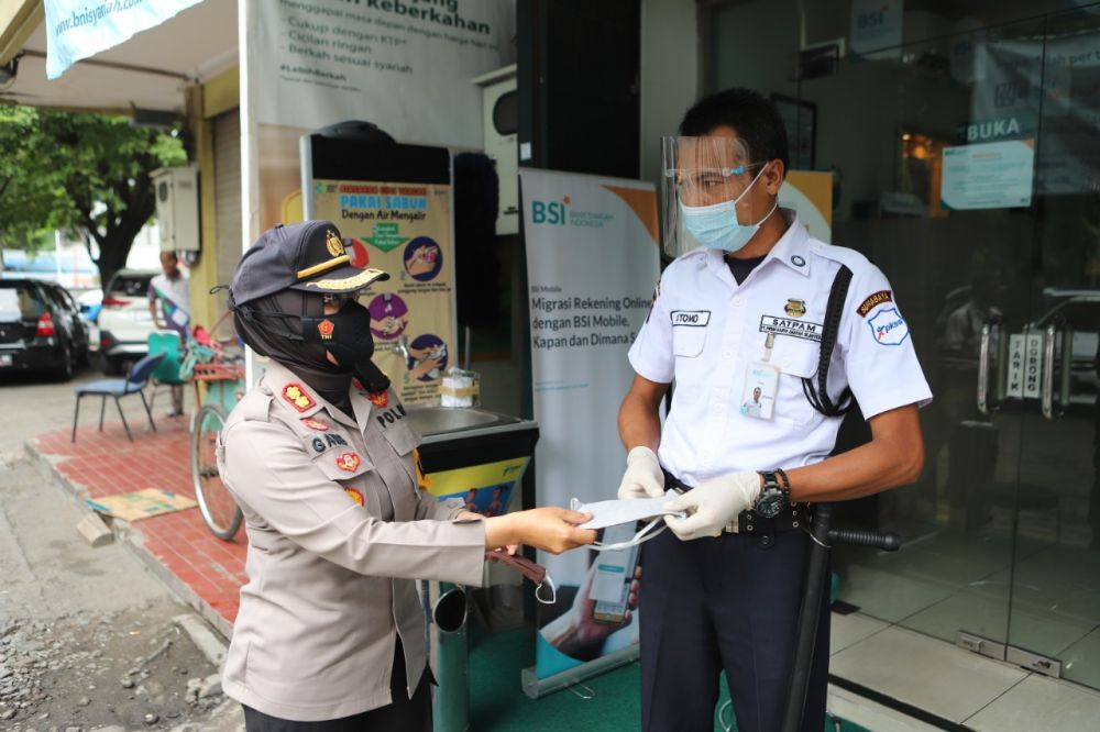 Kapolres Pelabuhan Tanjung Perak Surabaya AKBP Ganis Setyaningrum berbagi masker ke pejalan kaki dan pedagang
