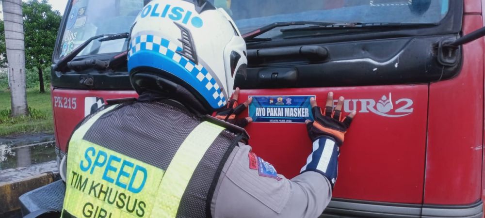 Satlantas Polres Gresik menempelkan stiker himbauan memakai masker