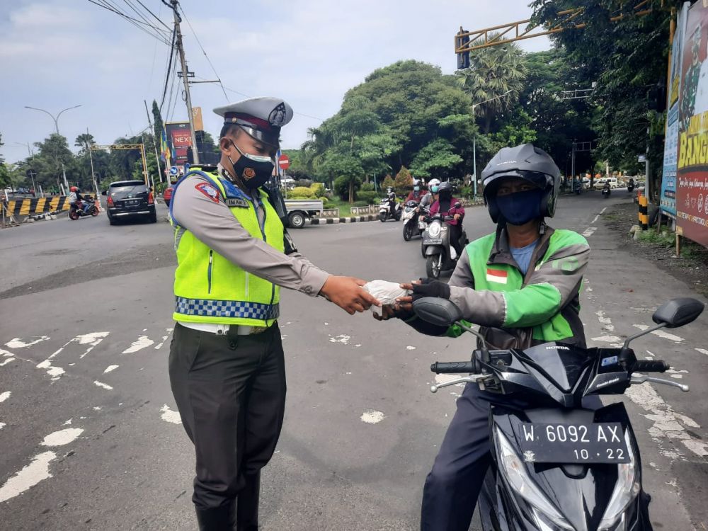 Satlantas Polres Gresik berbagi nasi bungkus pada warga terdampak Covid-19