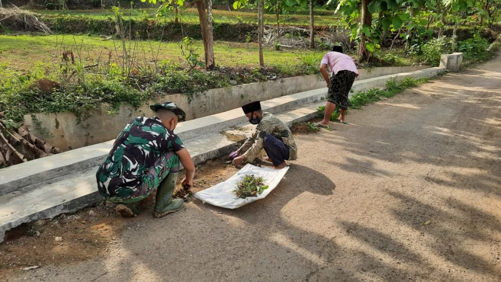 Anggota Kodim 0826 Pamekasan bersama warga saat membersihkan jalan