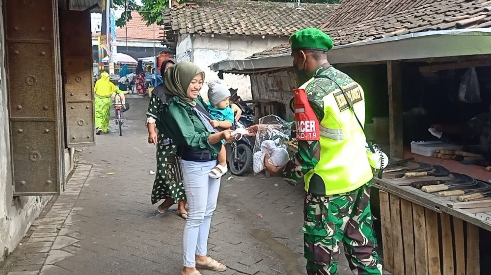 Serda Lukman saat membagikan masker gratis ke ibu dan anak di pasar tradisional