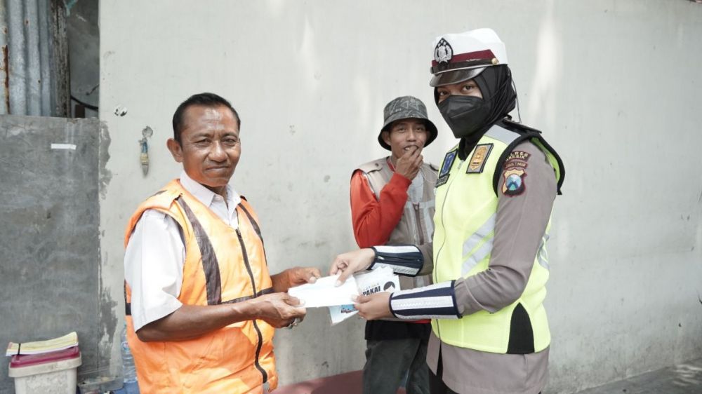 Polwan Polres Gresik saat berbagi masker ke pengguna jalan yang lupa gunakan masker