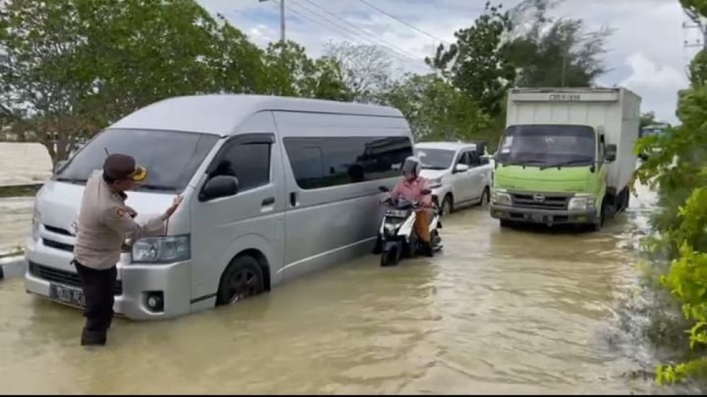 Personel Polres Sumenep lakukan pengaturan kendaraan R2, R4 dan R6 saat banjir melanda