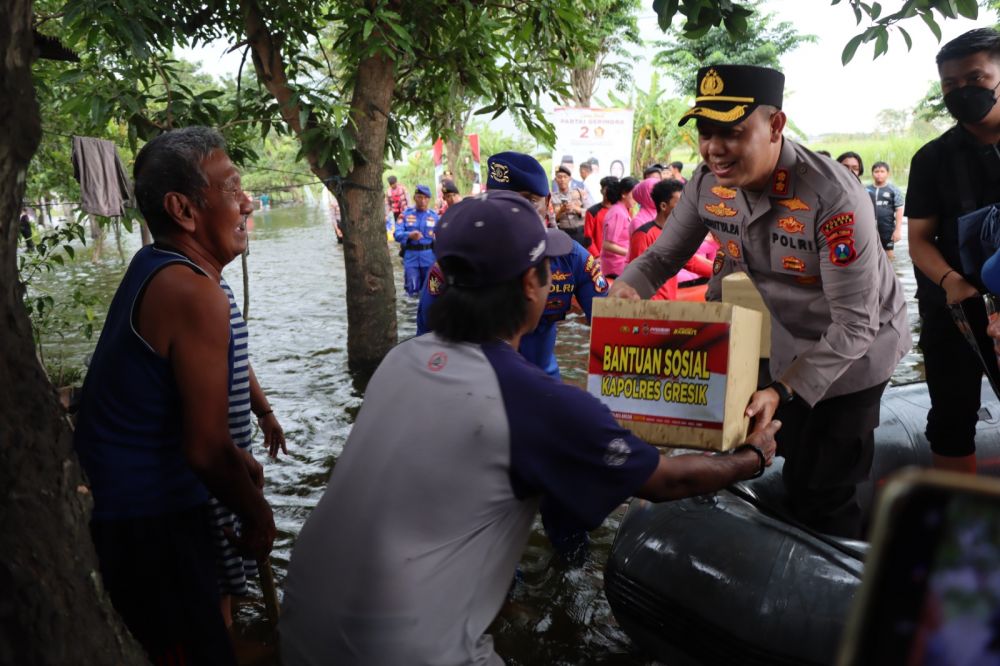 Kapolres Gresik AKBP Adhitya Panji Anom saat memberikan bingkisan ke warga terdampak banjir